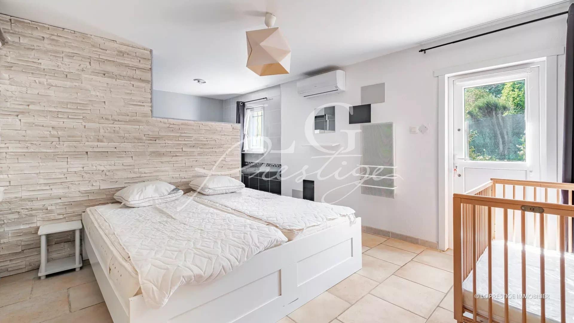 Chambre d'une villa de plain-pied à Fayence avec lit double et lit bébé.