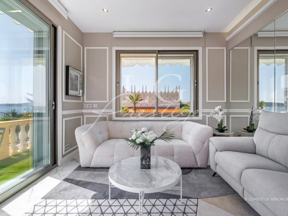 Salon lumineux d'un appartement rénové à Cannes, avec vue sur la mer et accès à une terrasse.