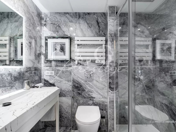 Salle de bain moderne avec carrelage en marbre et équipements contemporains.