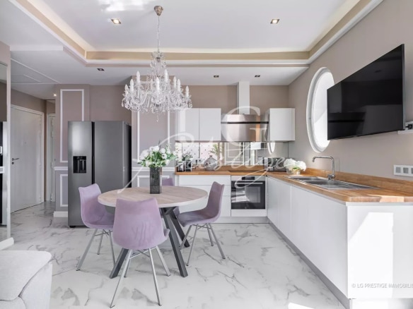 Cuisine moderne et lumineuse avec salle à manger dans un appartement rénové à Cannes.