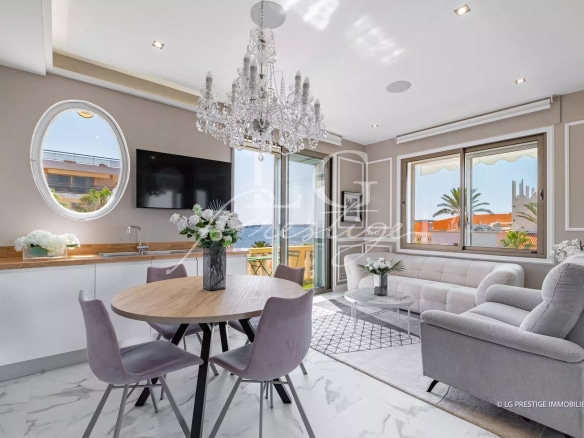 Intérieur d'un appartement rénové à Cannes, avec salon, salle à manger et cuisine ouverte.