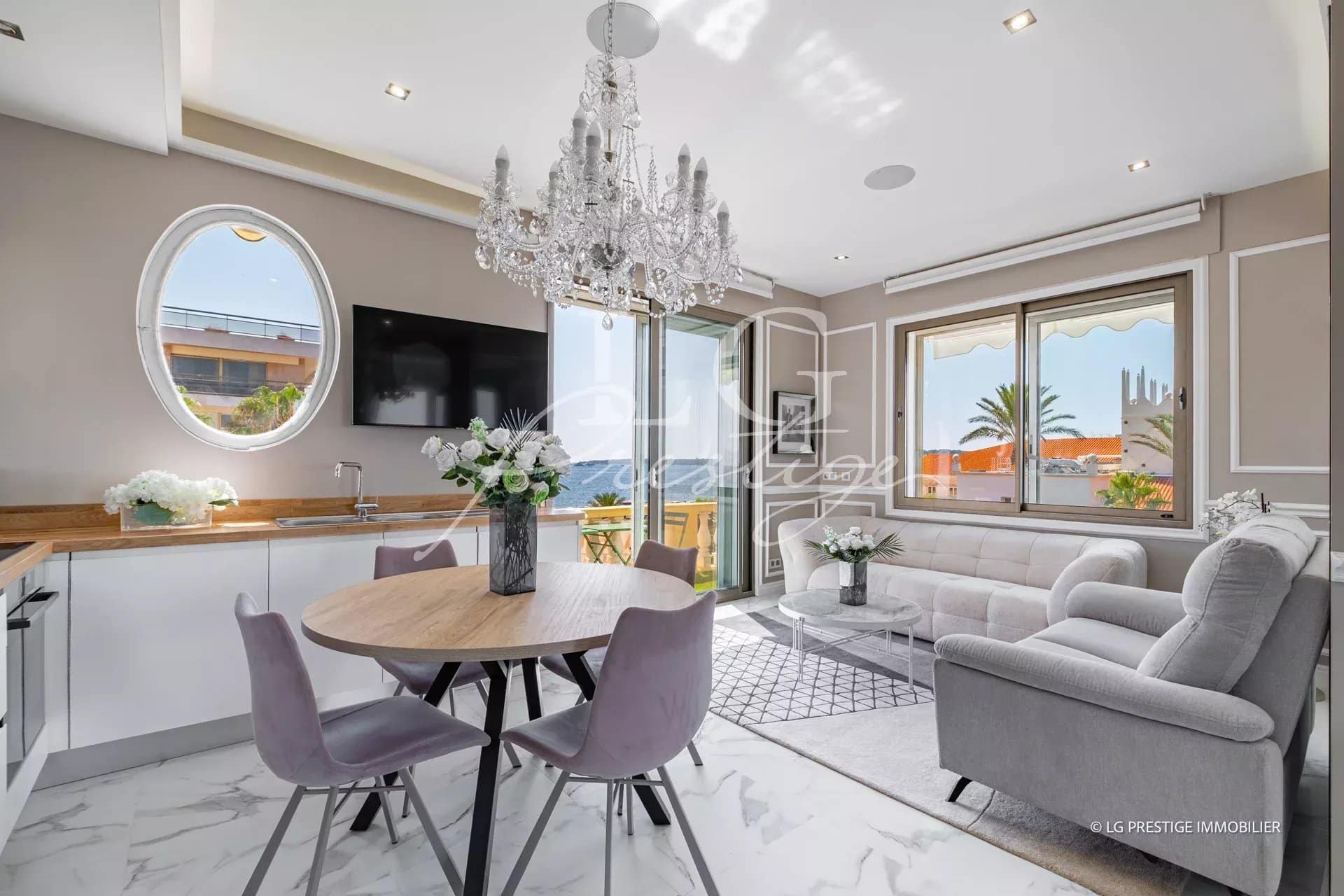 Intérieur d'un appartement rénové à Cannes, avec salon, salle à manger et cuisine ouverte.