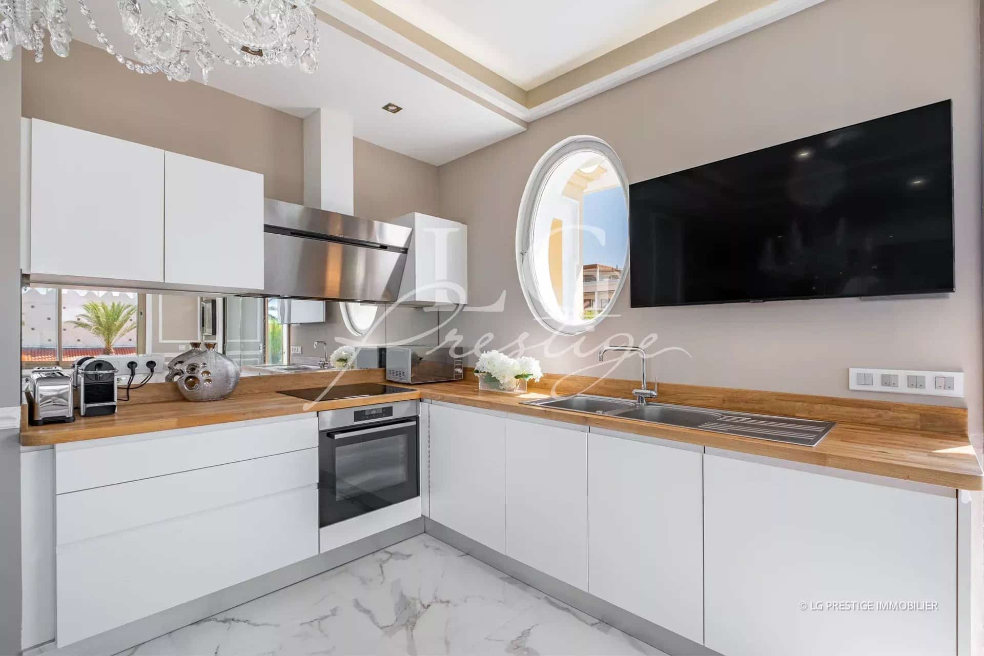 Cuisine moderne avec plans de travail en bois et appareils électroménagers intégrés.