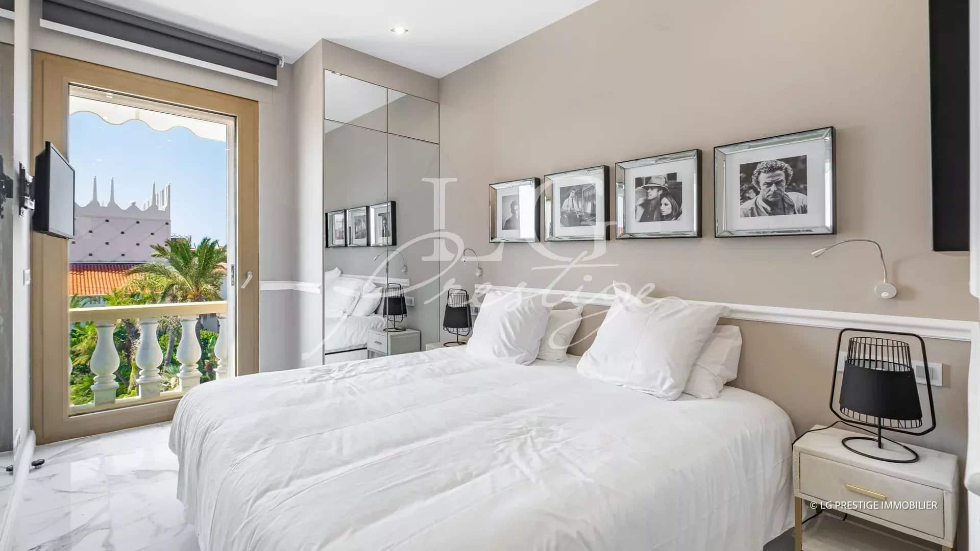 Chambre d'un appartement rénové à Cannes avec lit double et décoration moderne.