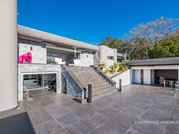 Villa contemporaine à Mandelieu-La-Napoule avec piscine et terrasses, vue sur jardin.