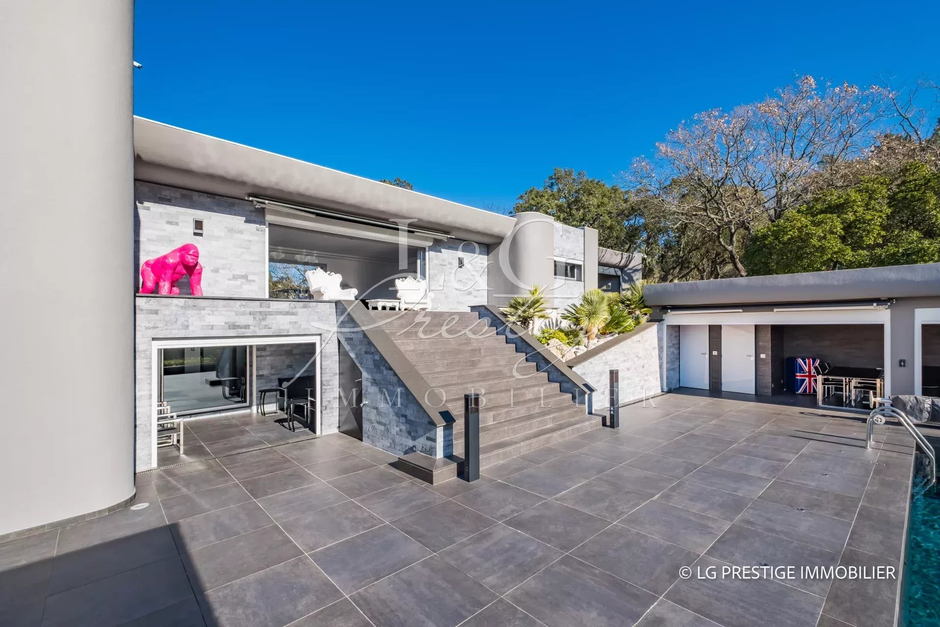 Villa contemporaine à Mandelieu-La-Napoule avec piscine et terrasses, vue sur jardin.