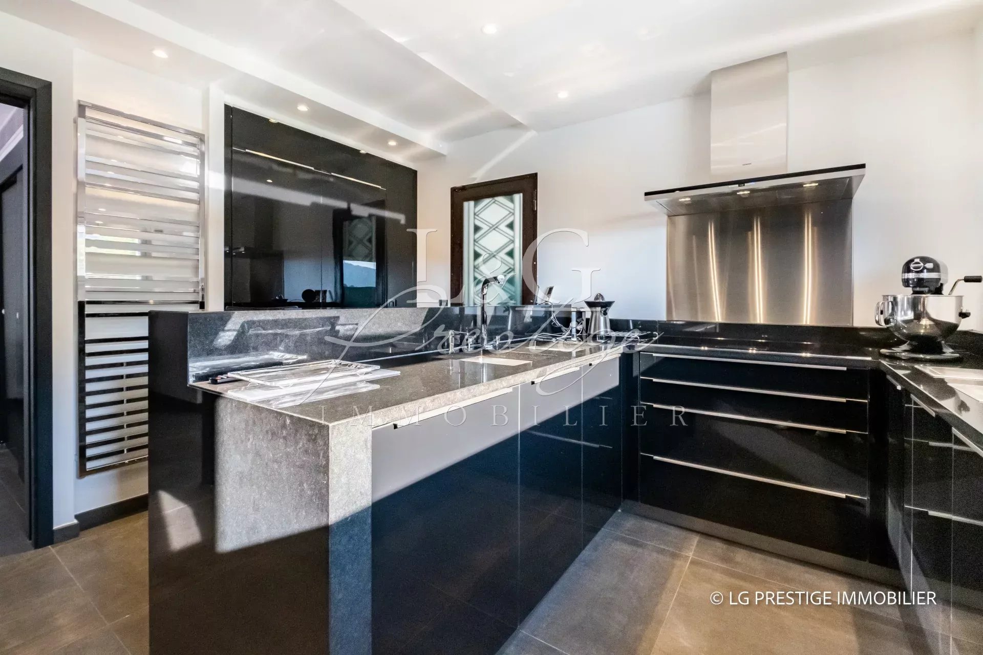 Cuisine moderne avec plan de travail en granite et équipements haut de gamme dans une villa contemporaine.