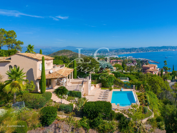 Panoramic view of a Provençal villa with swimming pool in Théoule-sur-Mer, surrounded by greenery and sea.