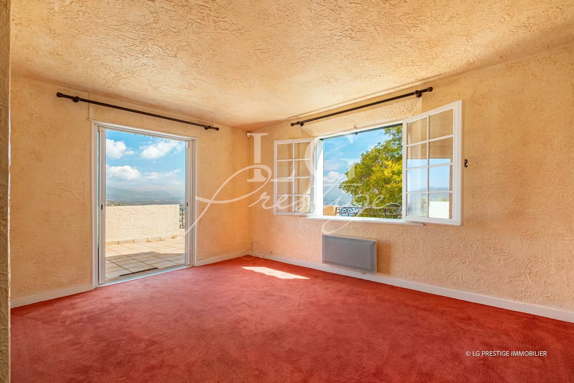 Interior of a villa in Théoule-sur-Mer with sea view, light walls and open windows.