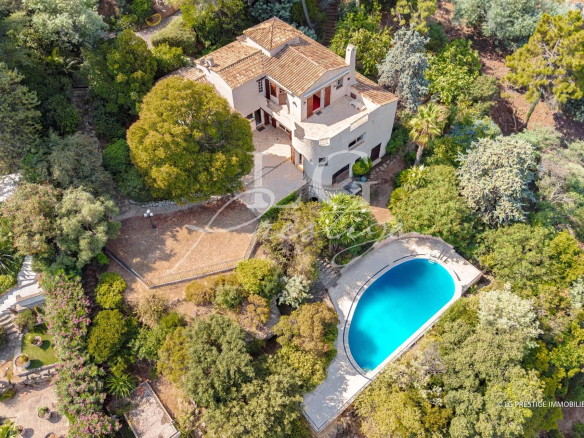 Aerial view of a villa with swimming pool and garden in Théoule-sur-Mer.