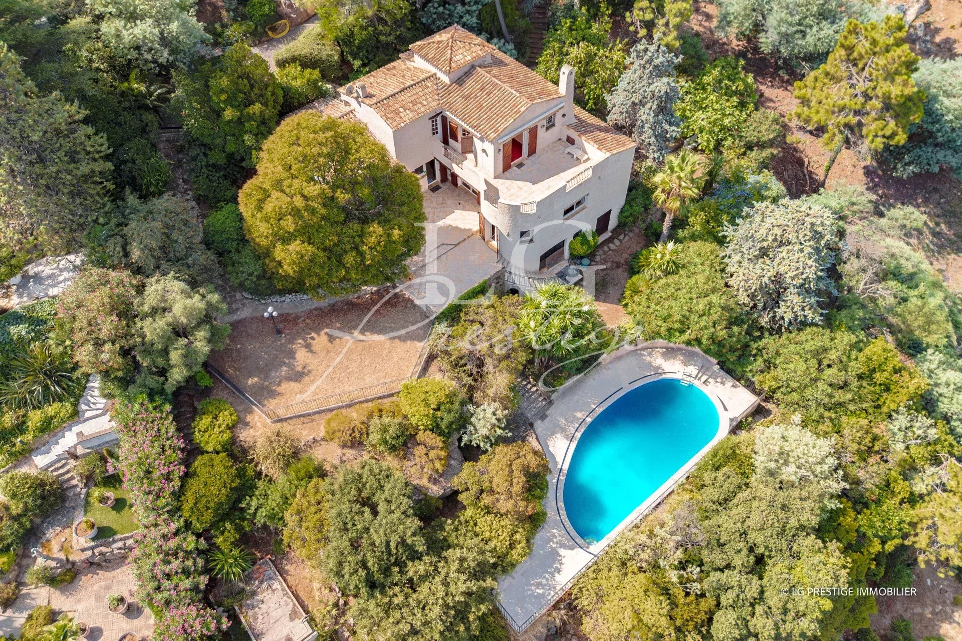 Aerial view of a villa with swimming pool and garden in Théoule-sur-Mer.