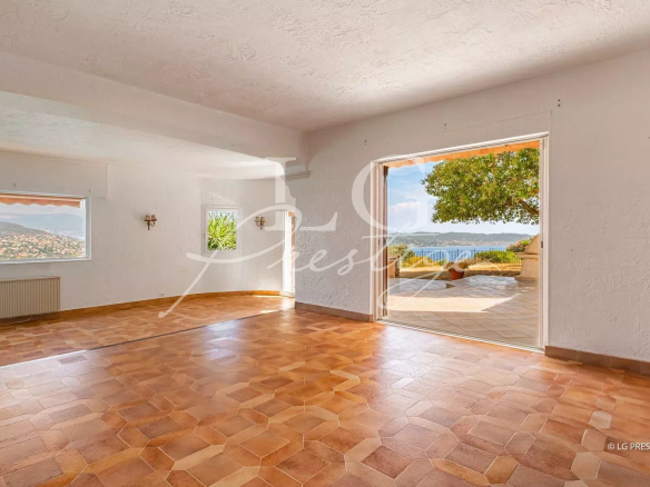 Interior of a villa in Théoule-sur-Mer with sea view, tiled floor and open windows.