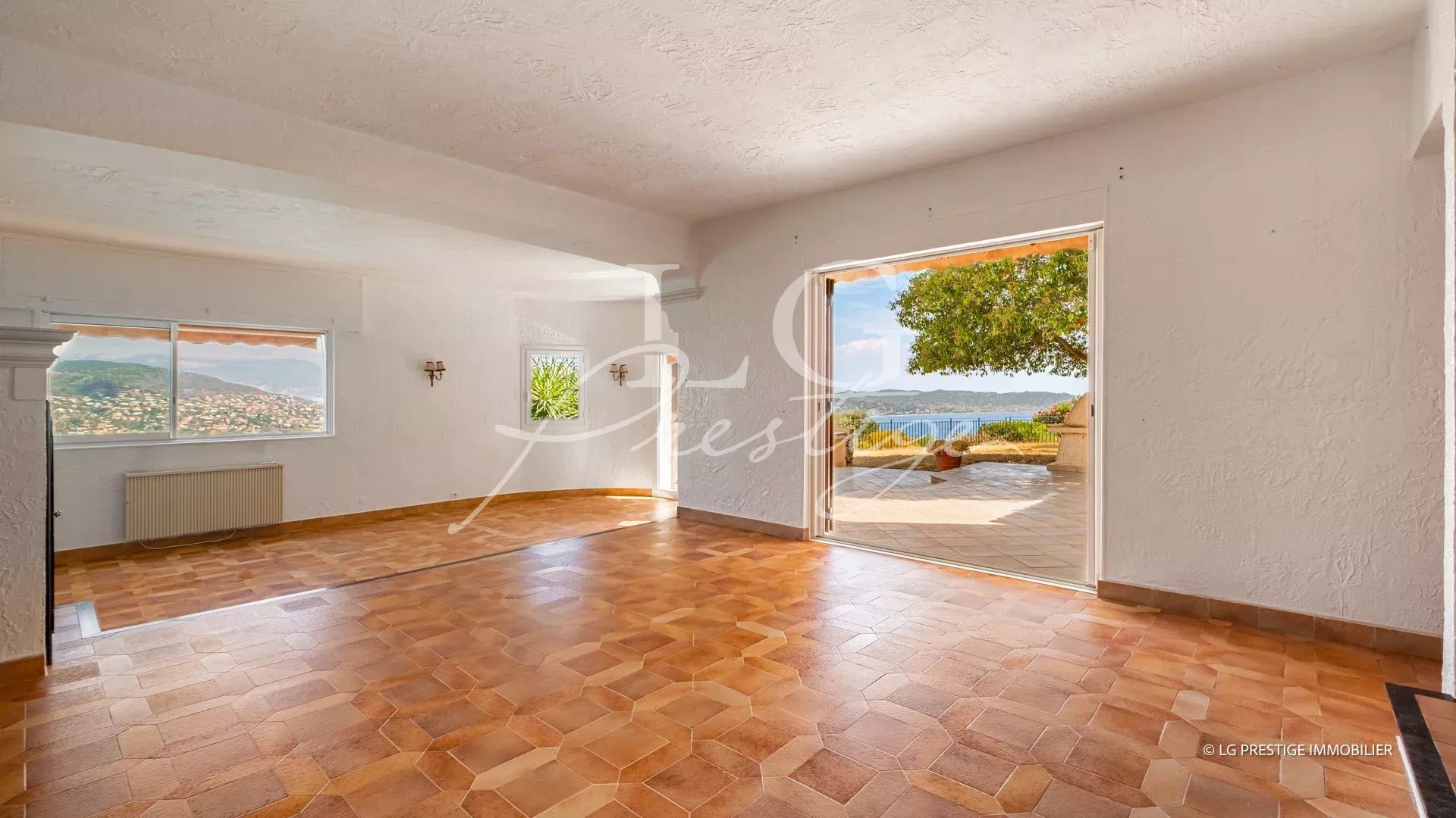 Interior of a villa in Théoule-sur-Mer with sea view, tiled floor and open windows.