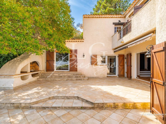 Terrace of a villa with sea view, surrounded by trees in Théoule-sur-Mer.