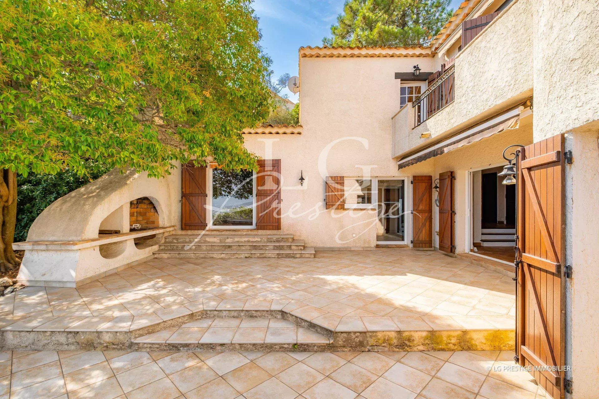 Terrace of a villa with sea view, surrounded by trees in Théoule-sur-Mer.