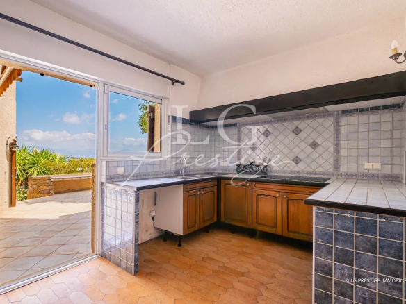 Open kitchen with sea view in Théoule-sur-Mer, windows overlooking the outside.