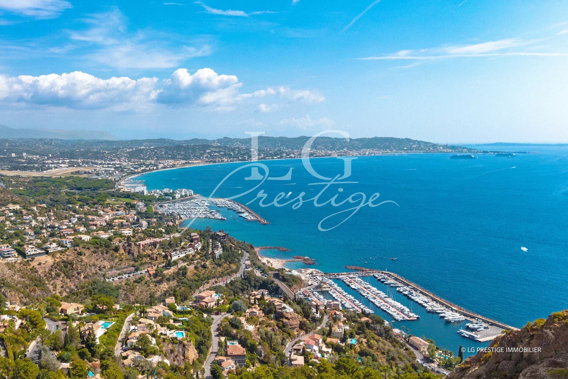 Panoramic view of the sea and the coast of Théoule-sur-Mer, with yachts in the port.