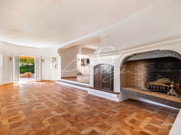 Interior of a villa in Théoule-sur-Mer with fireplace and tiled floor.