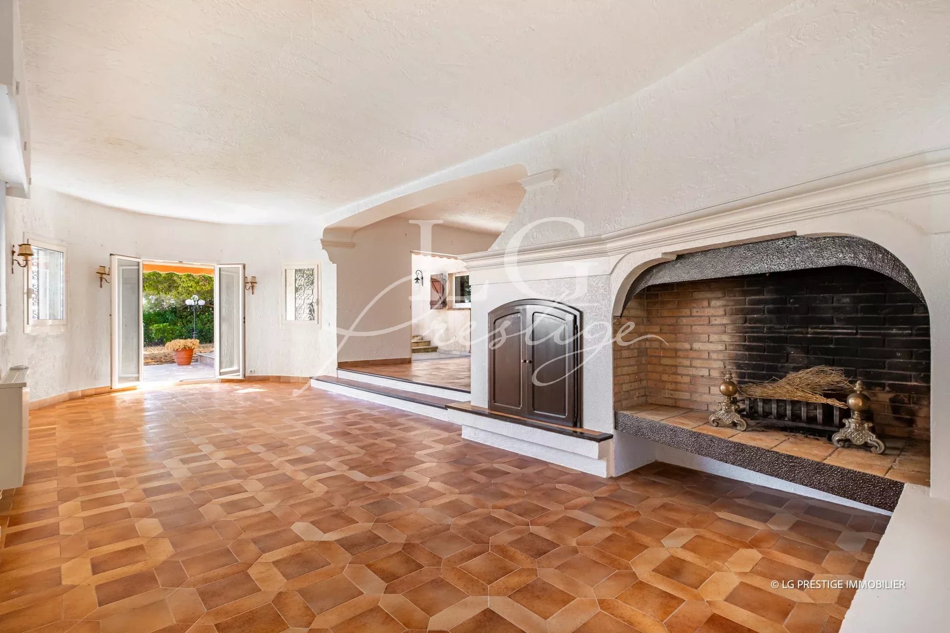 Interior of a villa in Théoule-sur-Mer with fireplace and tiled floor.