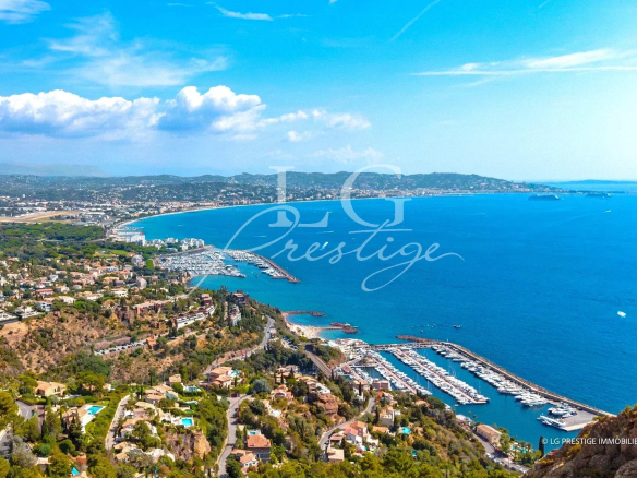 Vue panoramique sur la mer et la côte depuis Théoule-sur-Mer, avec des bateaux dans le port.