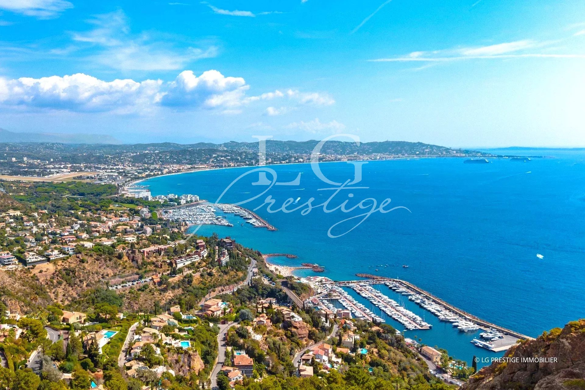 Vue mer à Théoule-sur-Mer Vue panoramique sur la mer et la côte depuis Théoule-sur-Mer, avec des bateaux dans le port.
