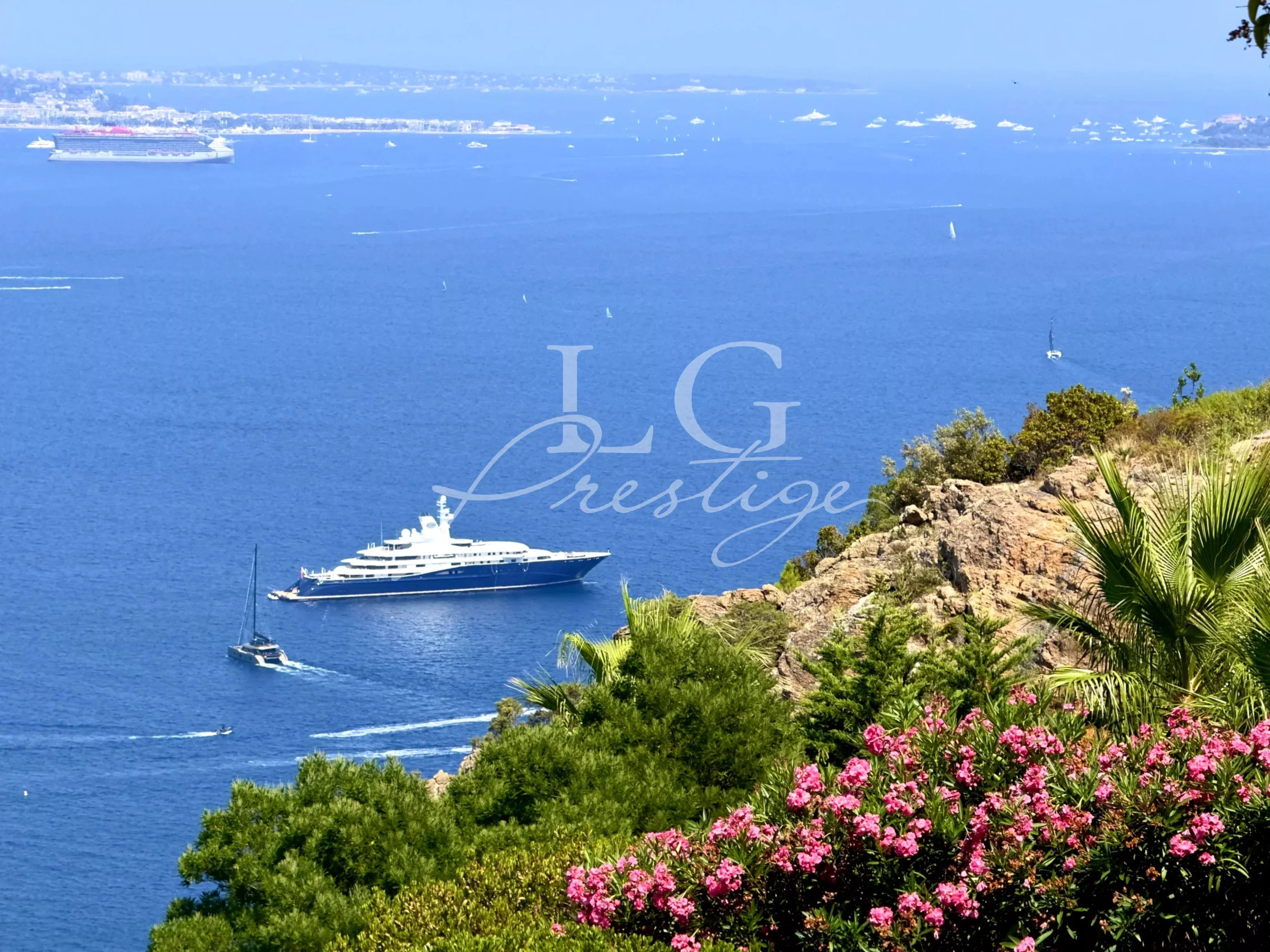 Vue mer à Théoule-sur-Mer Vue sur la mer avec un yacht et des fleurs en premier plan à Théoule-sur-Mer.