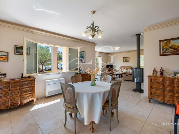 Intérieur d'une villa provençale avec mobilier en bois, table à manger et cheminée.