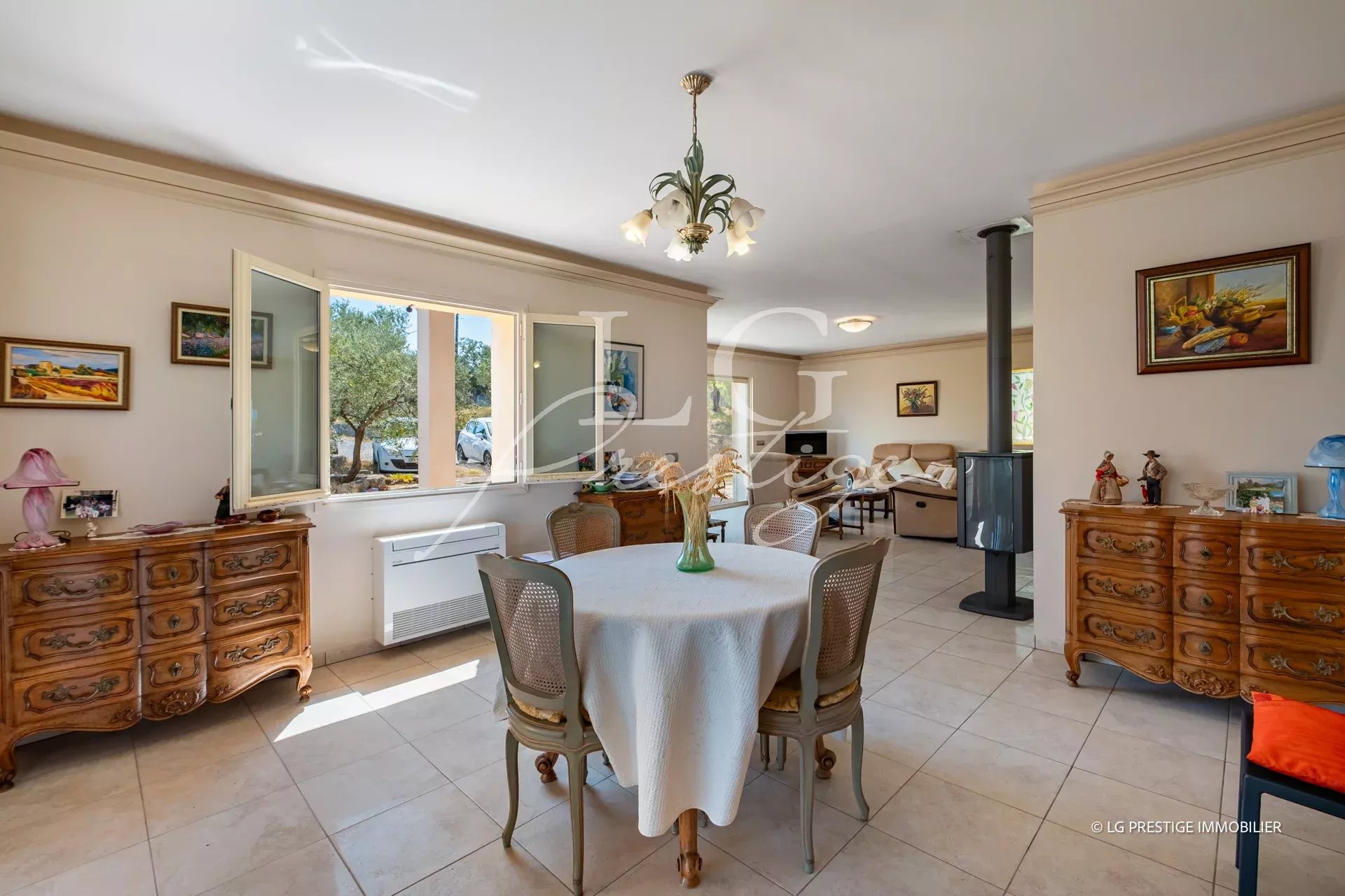 Intérieur d'une villa provençale avec mobilier en bois, table à manger et cheminée.