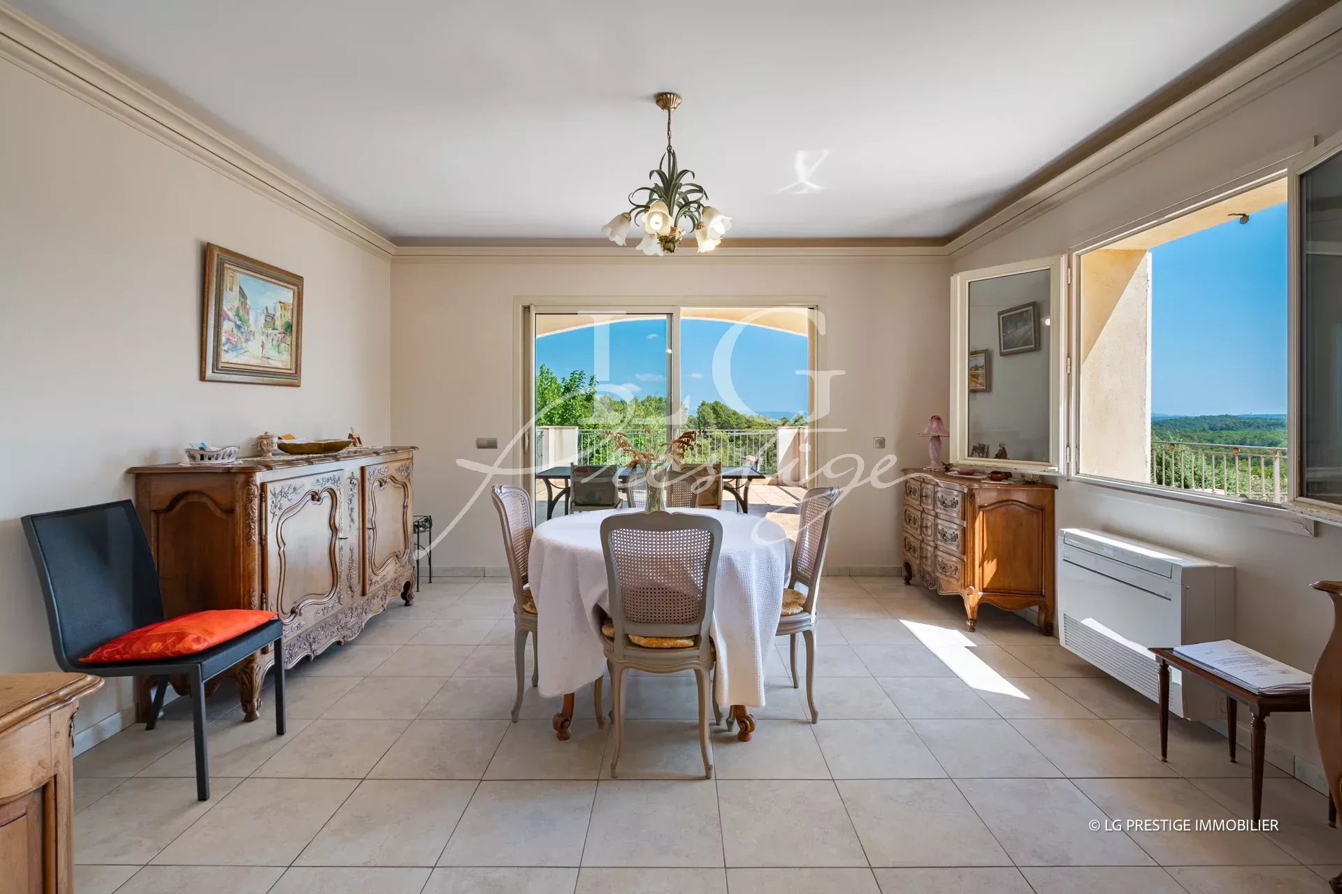Intérieur d'une villa provençale avec salle à manger lumineuse et vue sur la nature.