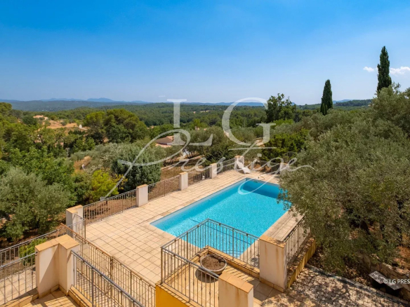 Vue d'une villa avec piscine entourée d'oliviers et de paysages provençaux à Seillans.
