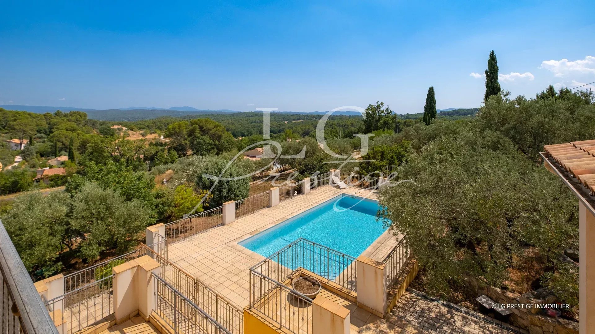 Vue d'une villa avec piscine entourée d'oliviers et de paysages provençaux à Seillans.