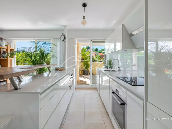 Modern and bright kitchen in an apartment in Mandelieu-la-Napoule, with a view from a balcony.