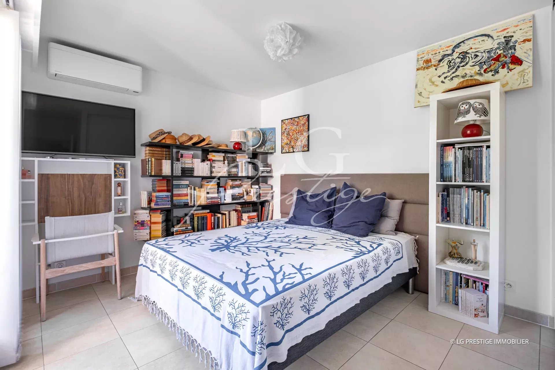 Apartment room in Mandelieu-la-Napoule Room in a modern apartment with bed, bookcase and television.