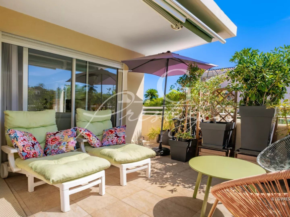 Apartment terrace with sun loungers and parasol in Mandelieu-la-Napoule.