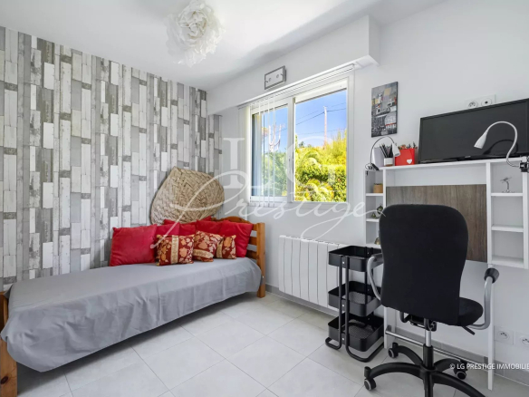 Interior of an apartment in Mandelieu-la-Napoule with a sofa, a desk and decorated walls.