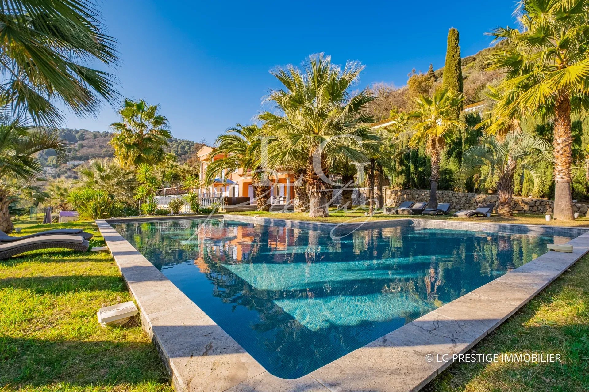 Demeure avec piscine chauffée et jardin luxuriant à Grasse, vue sur la nature environnante.
