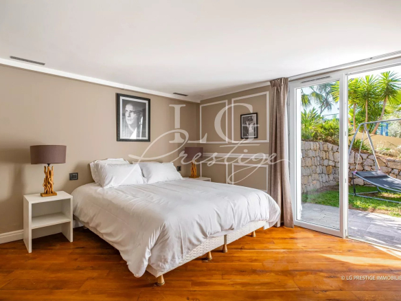 Chambre d'une maison à Grasse avec lit double et accès à un jardin.