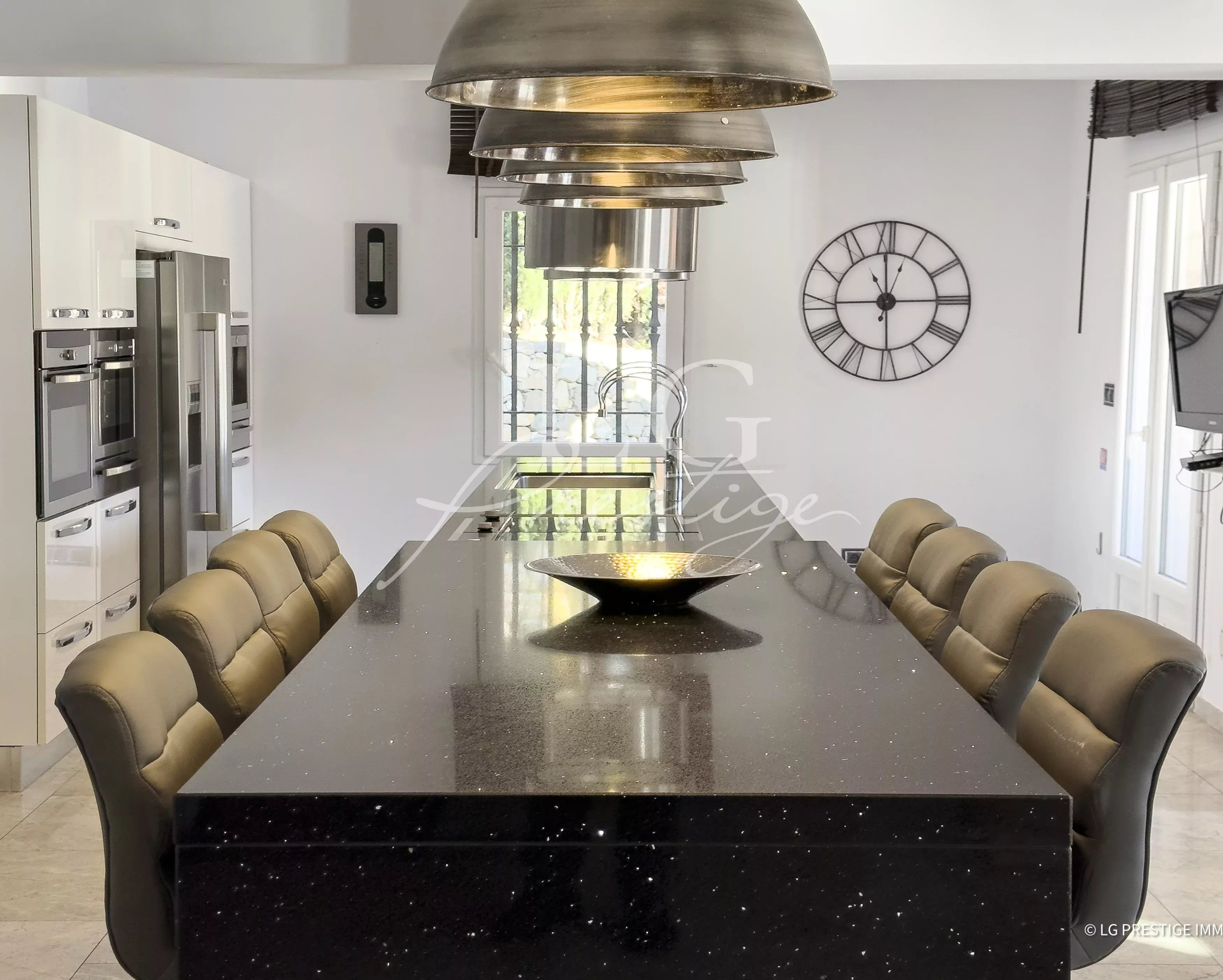 Cuisine moderne avec une grande table en marbre et des chaises confortables.