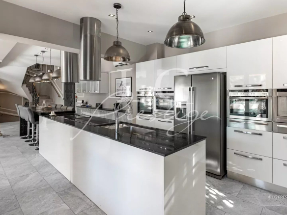Cuisine moderne avec îlot central et appareils électroménagers intégrés dans une maison à Grasse.