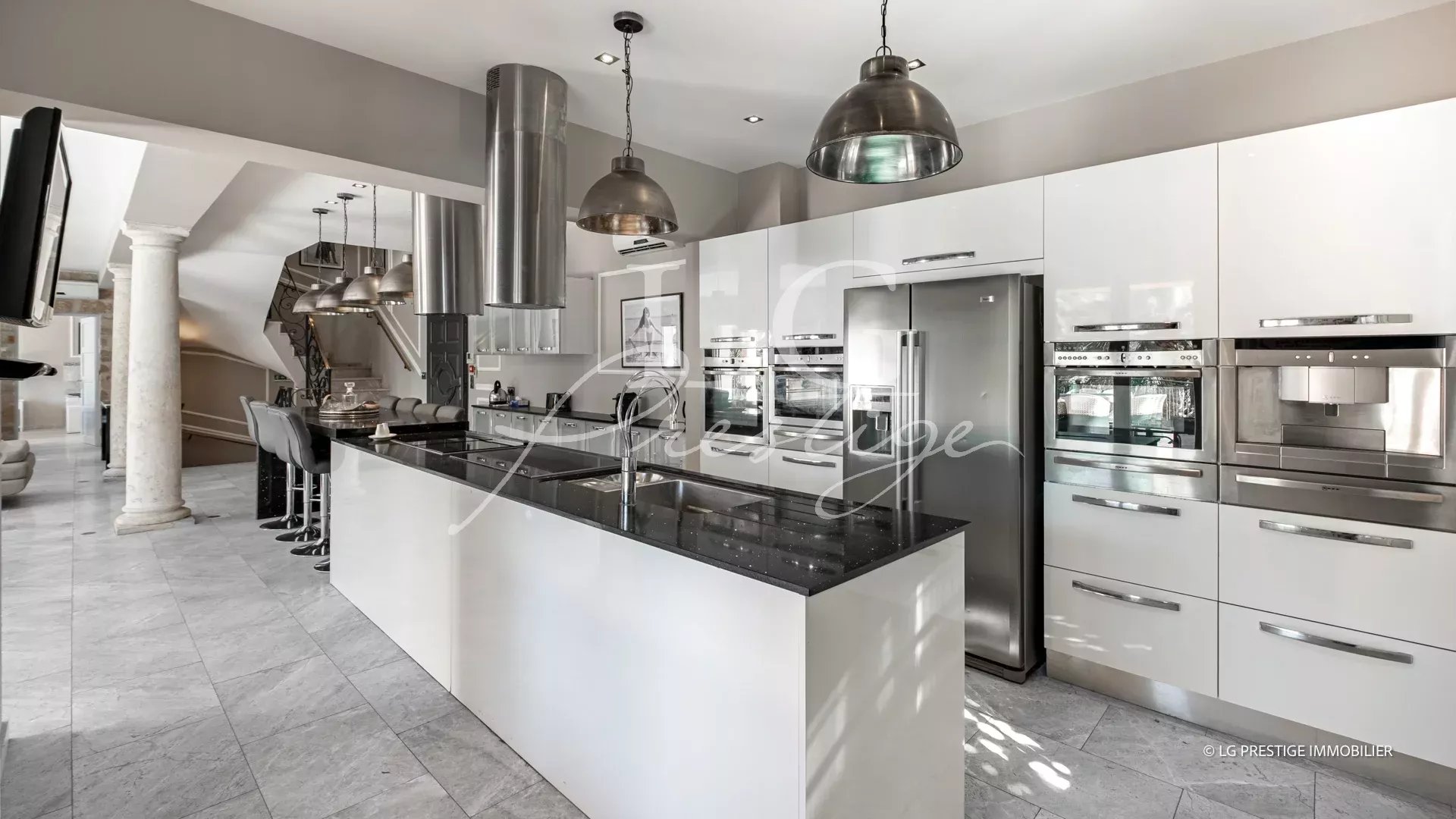 Cuisine moderne avec îlot central et appareils électroménagers intégrés dans une maison à Grasse.