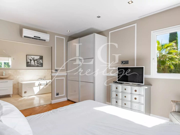 Chambre d'une propriété à Grasse avec salle de bain attenante et vue sur la végétation.