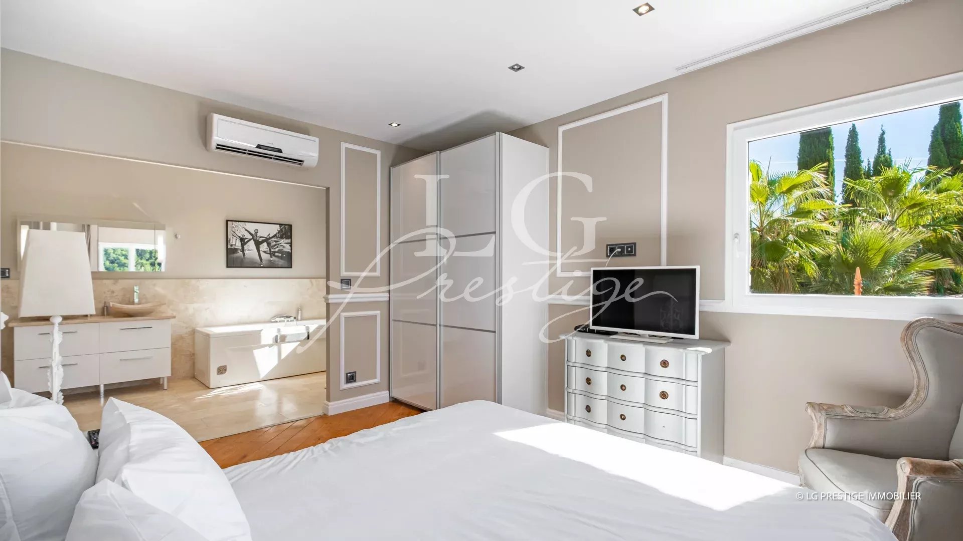 Chambre d'une propriété à Grasse avec salle de bain attenante et vue sur la végétation.