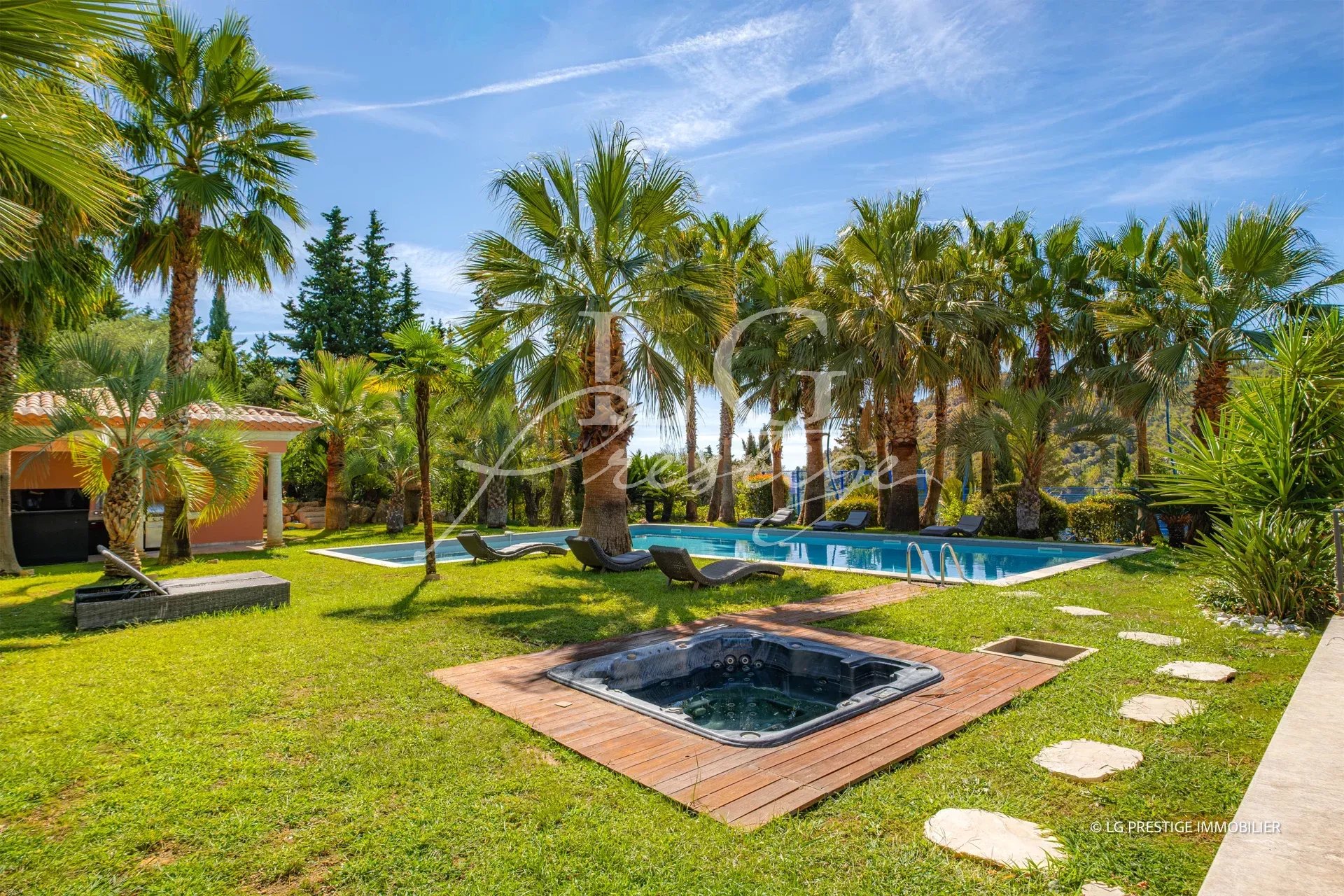 Jardin avec piscine et jacuzzi entouré de palmiers à Grasse.