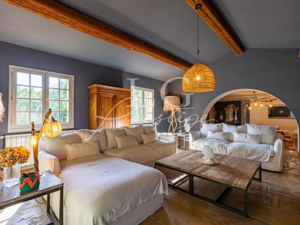 Interior of a Provençal villa in Seillans, bright living room with sofas and fireplace.