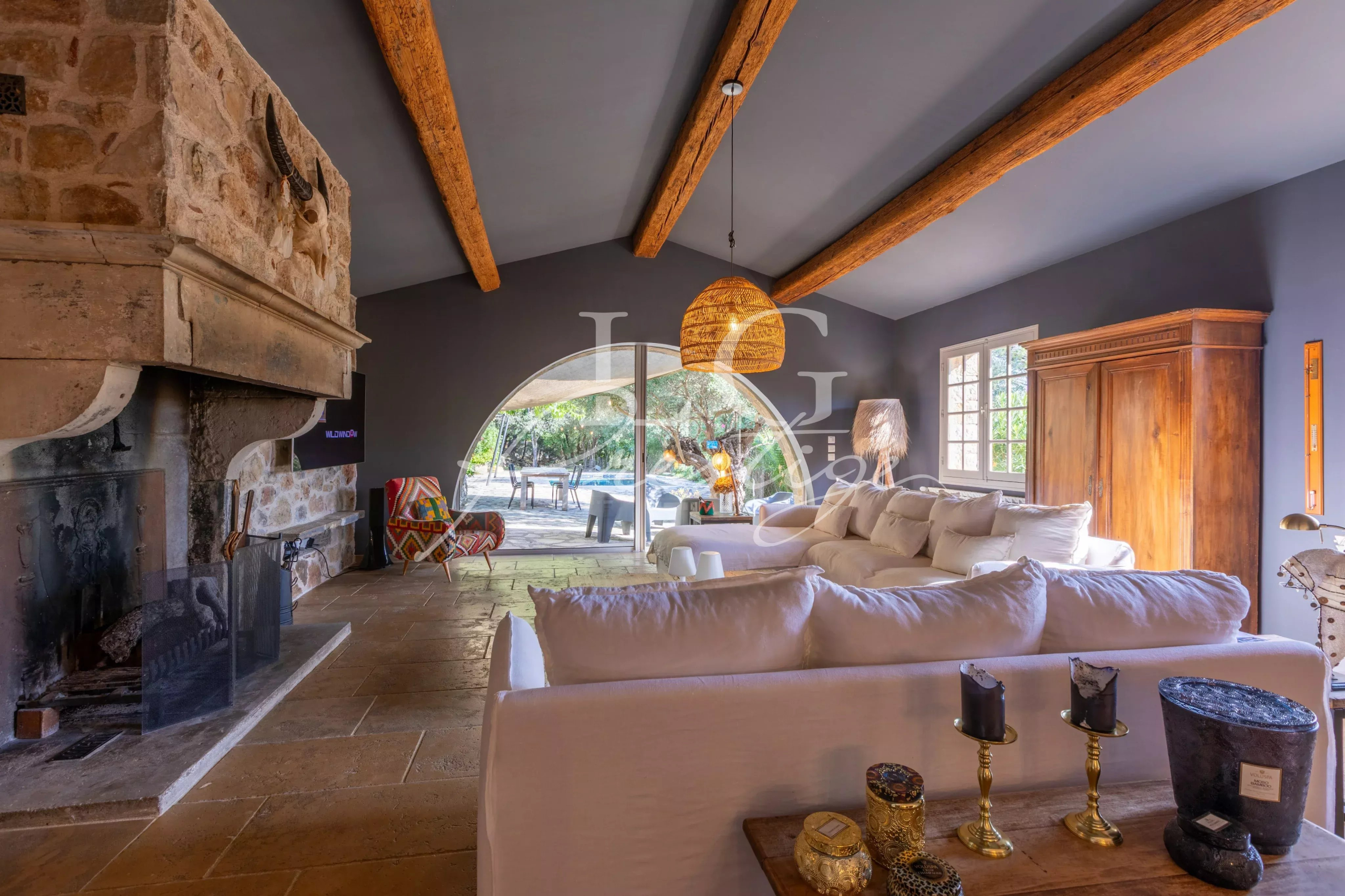 Interior of a Provençal villa Interior of a Provençal villa with fireplace, white sofas and large windows overlooking the outside.