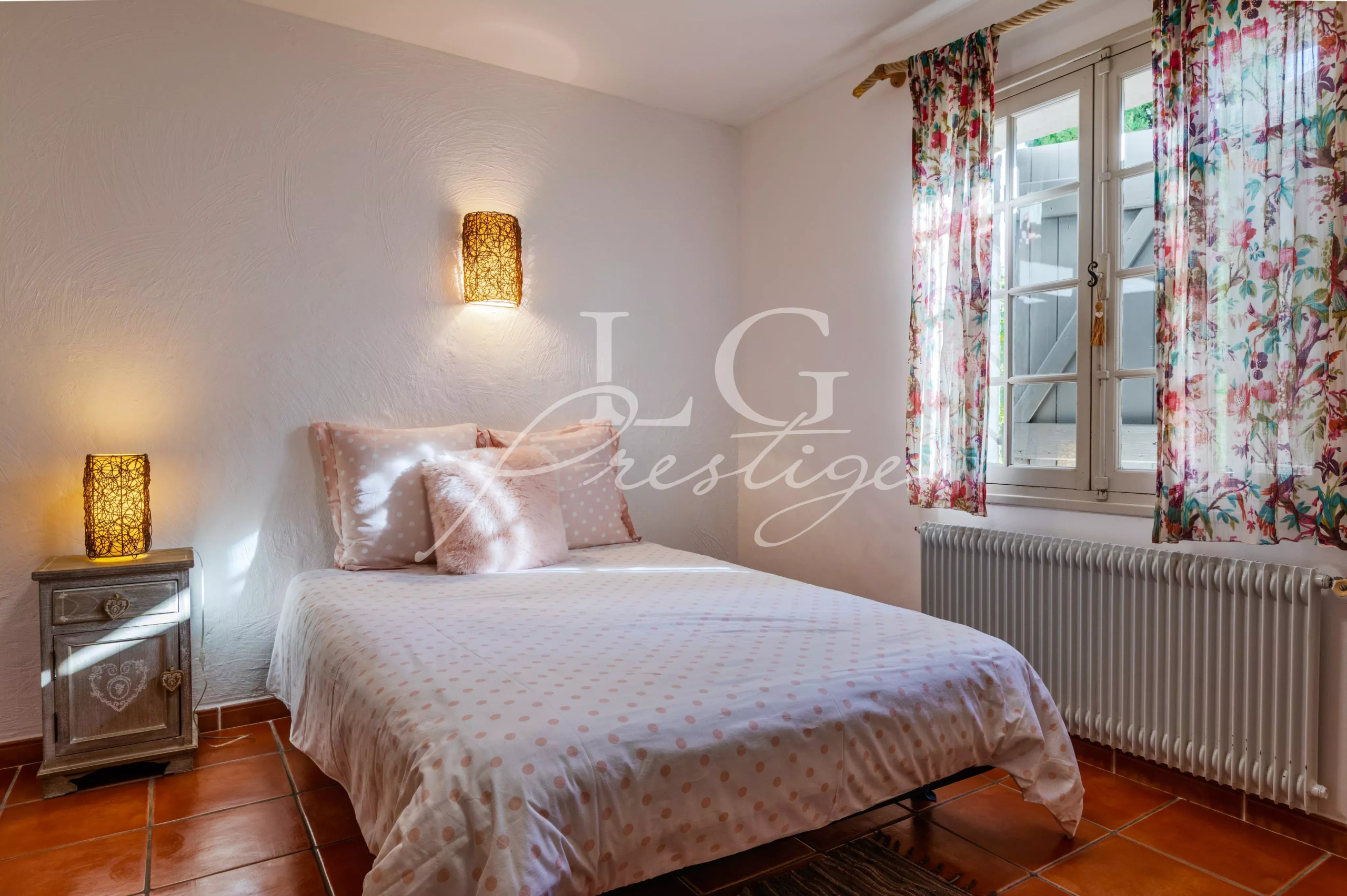 Room in a Provençal villa in Seillans Room in a Provençal villa with a double bed, decorated with floral curtains and soft lighting.