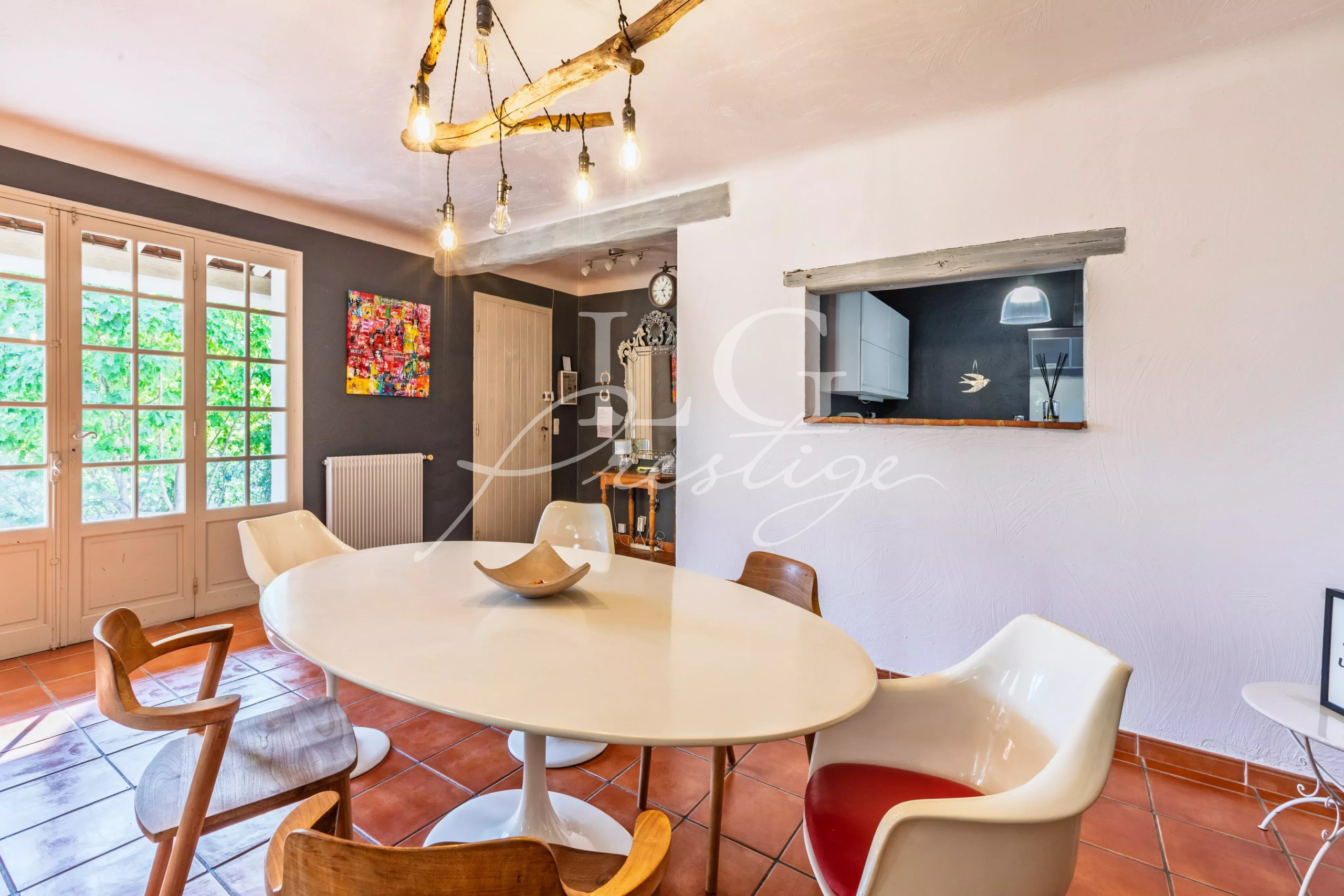 Interior of a Provençal villa Interior of a Provençal villa with a round table and modern chairs, bathed in light.