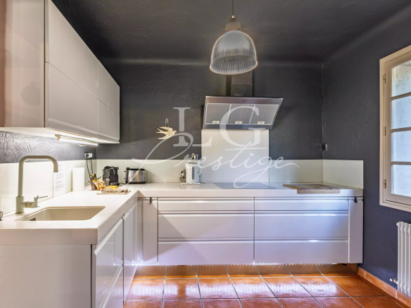 Modern and bright kitchen in a Provençal villa in Seillans, with white furniture and a quartz worktop.
