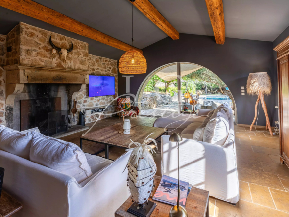 Interior of a Provençal villa with fireplace, bright living room and warm decor.