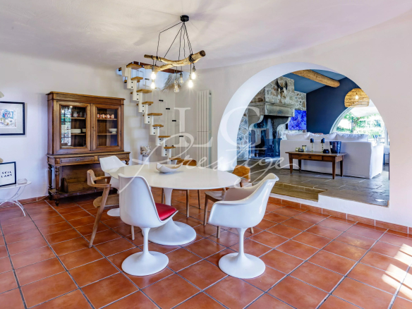 Interior of a Provençal villa with dining room and fireplace, warm and bright atmosphere.
